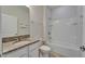 Bathroom features a vanity with granite countertop, tiled shower and tub, and white cabinets at 2612 Canyon Crest Dr, Lakeland, FL 33811