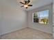 Bright bedroom features a ceiling fan, neutral paint, and view of the outdoors through the window at 2612 Canyon Crest Dr, Lakeland, FL 33811