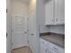 Neutral laundry room features granite counters, cabinets, tile backsplash and doors at 2612 Canyon Crest Dr, Lakeland, FL 33811