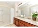 Bathroom features double sinks with granite countertops, a full mirror, and a shower with a white shower curtain at 5247 Wildwood Way, Davenport, FL 33837
