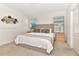 Bright bedroom with neutral carpet, natural wood end tables, lamps, and a king bed with decorative pillows at 5247 Wildwood Way, Davenport, FL 33837