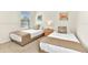 Bright bedroom with two twin beds, nautical themed decor, and carpeted floor at 5247 Wildwood Way, Davenport, FL 33837