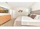 Bright bedroom with neutral carpet, natural wood furniture, king bed with decorative pillows, and a TV at 5247 Wildwood Way, Davenport, FL 33837