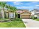 Charming single-Gathering home featuring a well-manicured lawn and beautiful palm trees at 5247 Wildwood Way, Davenport, FL 33837