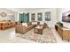Comfortable living room with a large sofa, patterned rug, and view of the backyard at 5247 Wildwood Way, Davenport, FL 33837