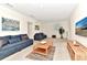 The living room has neutral carpet, natural wood furniture, and bright natural light from two windows at 5247 Wildwood Way, Davenport, FL 33837