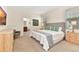 Spacious main bedroom with ensuite bathroom, large bed and neutral carpet flooring at 5247 Wildwood Way, Davenport, FL 33837