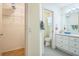 Bathroom with a walk-in closet, white cabinets and grey tile flooring at 9345 Se 171St Le Flore Ln, The Villages, FL 32162