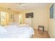 Bright bedroom with wood floors, an entertainment center, and views to the bathroom and laundry room at 9345 Se 171St Le Flore Ln, The Villages, FL 32162