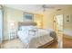 Bright bedroom features a wicker bedframe, hardwood floors, and an adjacent bathroom at 9345 Se 171St Le Flore Ln, The Villages, FL 32162