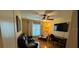 Cozy bedroom with a ceiling fan, dark leather couch and natural light from the window at 9345 Se 171St Le Flore Ln, The Villages, FL 32162