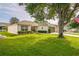 Charming single-story home featuring a well-manicured lawn, mature trees, and a side-entry two-car garage at 9345 Se 171St Le Flore Ln, The Villages, FL 32162