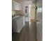 Functional laundry room with white cabinets and a washing machine next to the entry hallway at 9345 Se 171St Le Flore Ln, The Villages, FL 32162