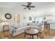 Bright living room featuring a comfortable sofa, hardwood floors, and an open layout leading to the dining area and kitchen at 9345 Se 171St Le Flore Ln, The Villages, FL 32162