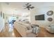 Open-concept living room featuring hardwood floors, a ceiling fan, and views into the dining area and kitchen at 9345 Se 171St Le Flore Ln, The Villages, FL 32162