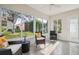 Bright sunroom with large windows, offering scenic views and comfortable seating, and a door for outdoor access at 9345 Se 171St Le Flore Ln, The Villages, FL 32162