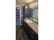 Elegant bathroom vanity with dark cabinetry, granite countertop, modern fixtures, and wood-look vinyl flooring at 1318 Herschell St, Lakeland, FL 33815