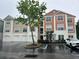 Three-story condominium building with brick and siding, tree, and handicap parking at 12849 Madison Pointe Cir # 204, Orlando, FL 32821