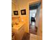 This is a partial view of the bathroom that leads to a bedroom with wood floors and a dark leather chair at 2073 Cr 428, Lake Panasoffkee, FL 33538
