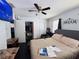 This bedroom features a ceiling fan, TV, closet, a leather chair, and natural light from the window at 2073 Cr 428, Lake Panasoffkee, FL 33538