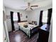 Bedroom with a ceiling fan, wood floor, dresser, window, and a large mirror at 2073 Cr 428, Lake Panasoffkee, FL 33538