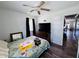 This bedroom features a ceiling fan, hard wood floors, TV, dresser, and a window for natural light at 2073 Cr 428, Lake Panasoffkee, FL 33538