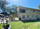 Two-story home exterior features wood siding, brick accents, stairs, and lovely lawn with ample greenery and landscaping at 2073 Cr 428, Lake Panasoffkee, FL 33538