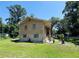 Two-story home featuring a brick foundation and charming curb appeal amidst a lush green lawn with mature trees at 2073 Cr 428, Lake Panasoffkee, FL 33538