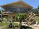 Charming two-story home with a combination of siding and brick, complemented by mature trees and outdoor staircase at 2073 Cr 428, Lake Panasoffkee, FL 33538
