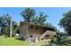 Two-story home exterior, showcasing the stairs, and landscaped yard with trees and patio set, perfect for relaxation at 2073 Cr 428, Lake Panasoffkee, FL 33538