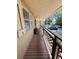 Side view of a covered porch with wooden railing, offering an outdoor space for relaxing and enjoying the surroundings at 2073 Cr 428, Lake Panasoffkee, FL 33538