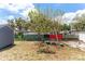View of the backyard with a bench under a tree and raised planting beds at 181 Osprey Heights Dr, Winter Haven, FL 33880