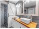 Modern bathroom features double sinks, decorative mirrors, barn-door shower entry, and mosaic tile accents at 181 Osprey Heights Dr, Winter Haven, FL 33880