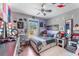 A bedroom with colorful wall decorations, a ceiling fan, and a window overlooking the backyard at 181 Osprey Heights Dr, Winter Haven, FL 33880