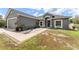 Charming gray home with a two-car garage, lush lawn, landscaped walkway, and inviting front entrance at 181 Osprey Heights Dr, Winter Haven, FL 33880