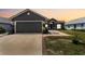 Charming gray home showcasing a two-car garage, front door, manicured lawn, and beautiful brick-lined walkway at 181 Osprey Heights Dr, Winter Haven, FL 33880