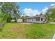 Expansive backyard view featuring a storage shed, lush green grass, and mature trees at 630 Pear St, Lakeland, FL 33815