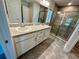 Bathroom featuring double vanity and standup shower with glass door at 1259 Groveland Ln, Lakeland, FL 33811