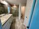 Bathroom featuring a double sink vanity and tiled glass shower at 1259 Groveland Ln, Lakeland, FL 33811