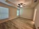 This bedroom includes a ceiling fan, two windows, and wood flooring at 1259 Groveland Ln, Lakeland, FL 33811