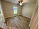 Bedroom featuring wood-look flooring, a ceiling fan, and a bright window at 1259 Groveland Ln, Lakeland, FL 33811