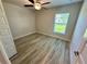 Bedroom with wood-look flooring, ceiling fan, and a window offering natural light at 1259 Groveland Ln, Lakeland, FL 33811