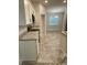 Updated kitchen with tile flooring, stone countertops, stainless steel appliances, and white cabinets at 1259 Groveland Ln, Lakeland, FL 33811