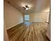 Bright living room featuring wood-look flooring, a ceiling fan, and a sliding glass door at 1259 Groveland Ln, Lakeland, FL 33811