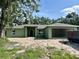 Exterior of single-Gathering home featuring green paint, attached garage, and lawn at 1265 Groveland Ln, Lakeland, FL 33811