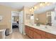 Bright bathroom with double vanity, tile floor, and a glimpse of the bedroom, perfect for morning routines at 2417 Passamonte Dr # 1E, Winter Park, FL 32792