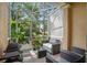 Relaxing screened patio with comfortable seating, a grill, and views of the lush greenery at 2417 Passamonte Dr # 1E, Winter Park, FL 32792