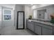 Bathroom featuring dual sinks, tile floors, a large mirror, and plenty of storage space at 5189 Greenheart Ave, Mount Dora, FL 32757