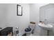 Half bathroom features toilet, sink, pedestal sink, and dark wood cabinet at 5189 Greenheart Ave, Mount Dora, FL 32757