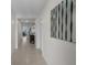 Hallway with tile flooring leading to dining area, featuring modern, decorative wall mirror at 5189 Greenheart Ave, Mount Dora, FL 32757